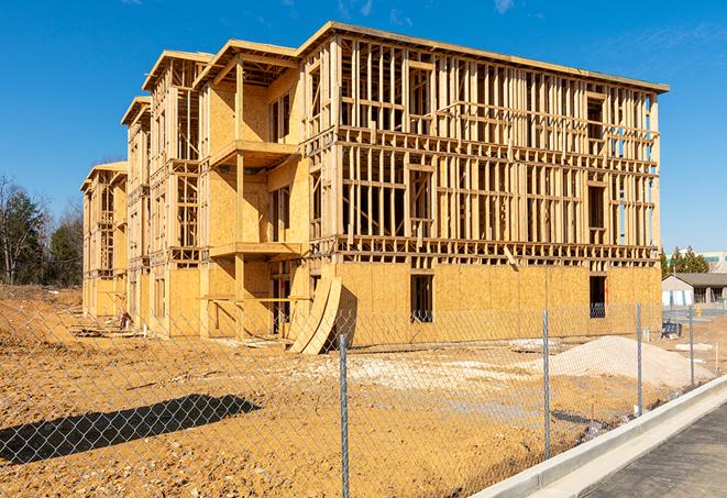 a close-up of temporary chain link fences enclosing a job site, signaling progress in the project's development in Canton, MA